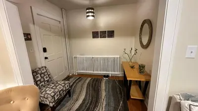 a living room with a chair and a table at Cozy Albany Home in Albany