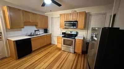 a kitchen with wooden cabinets and stainless steel appliances at Cozy Albany Home in Albany