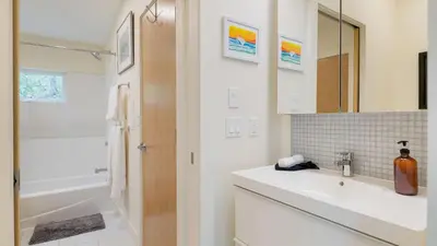 a bathroom with a sink and a tub and a mirror at Secluded Modern Enclosed Patio Forest Views Woodland Zen by AvantStay in Stockbridge