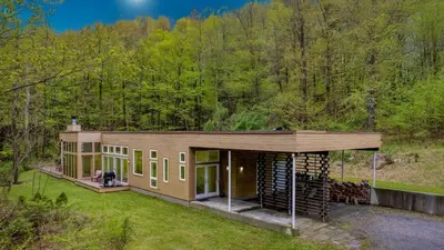 a house in the middle of a forest at Secluded Modern Enclosed Patio Forest Views Woodland Zen by AvantStay in Stockbridge