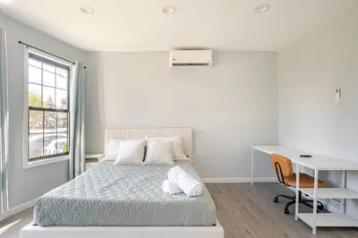 a bedroom with a bed and a desk and a window at Modern Apartment in Black Rock- in Bridgeport