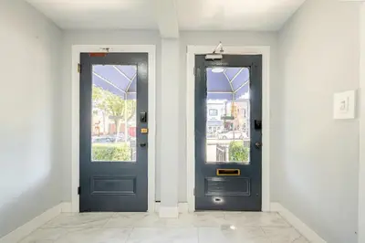 two blue doors in a white room with windows at Modern Apartment in Black Rock- in Bridgeport