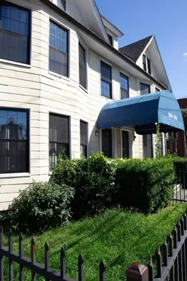 a white house with a blue umbrella in front of it at Modern Apartment in Black Rock- in Bridgeport