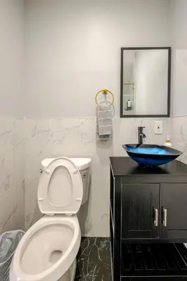 a bathroom with a toilet and a blue sink at Modern Apartment in Black Rock- in Bridgeport