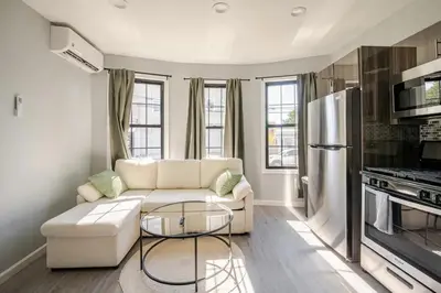 a living room with a white couch and a refrigerator at Modern Apartment in Black Rock- in Bridgeport