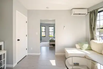 a white living room with a couch and a table at Modern Apartment in Black Rock- in Bridgeport