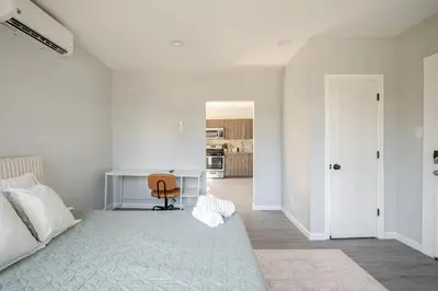 a white bedroom with a desk and a chair at Modern Apartment in Black Rock- in Bridgeport