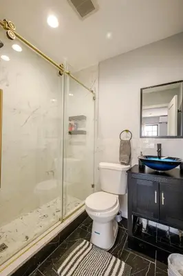 a bathroom with a toilet and a glass shower at Modern 3-Bdrm Apt in Black Rock in Bridgeport