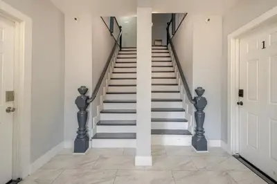 a staircase in a home with white walls at Modern 3-Bdrm Apt in Black Rock in Bridgeport