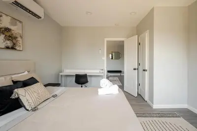 a bedroom with a large white bed and a chair at Modern 3-Bdrm Apt in Black Rock in Bridgeport