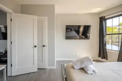 a white bedroom with a bed and a window at Modern 3-Bdrm Apt in Black Rock in Bridgeport