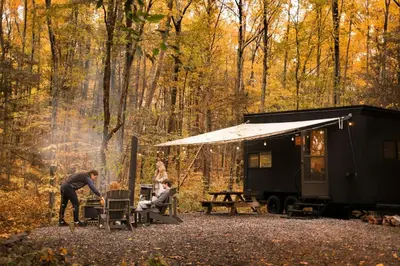 a group of people sitting at a table outside of a trailer at Postcard Cabins Machimoodus, Outdoor Collection by Marriott Bonvoy in Moodus