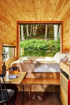 a bed in a wooden room with a window at Postcard Cabins Machimoodus, Outdoor Collection by Marriott Bonvoy in Moodus