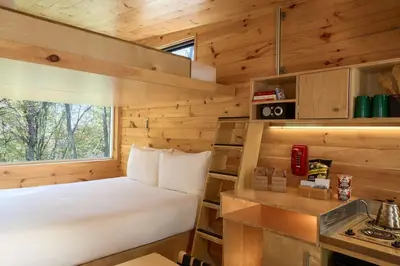 a small bedroom with a bed in a log cabin at Postcard Cabins Machimoodus, Outdoor Collection by Marriott Bonvoy in Moodus