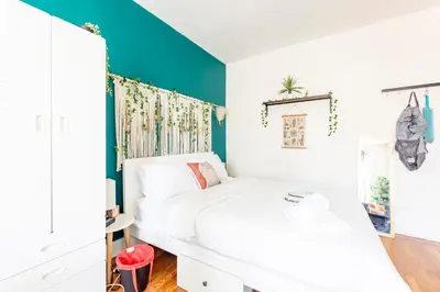 a bedroom with a white bed and a blue accent wall at Not operating in Jackson Heights