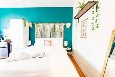 a bedroom with a white bed with a blue wall at Not operating in Jackson Heights