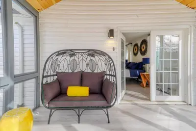 a purple chair with a yellow pillow on a porch at Brand New House with Large Porch in Lake Katrine in Lake Katrine