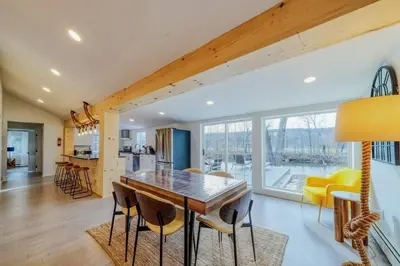 a kitchen and dining room with a wooden table and chairs at Brand New House with Large Porch in Lake Katrine in Lake Katrine