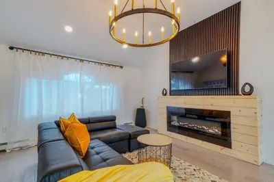 a living room with a couch and a fireplace at Brand New House with Large Porch in Lake Katrine in Lake Katrine
