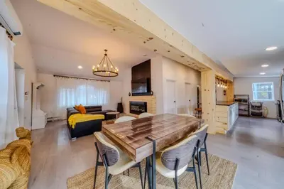 a kitchen and living room with a table and chairs at Brand New House with Large Porch in Lake Katrine in Lake Katrine