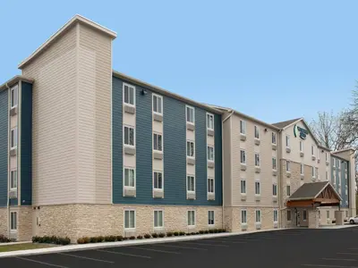 an apartment building with a blue and gray building at WoodSpring Suites Newington - Hartford South in Newington