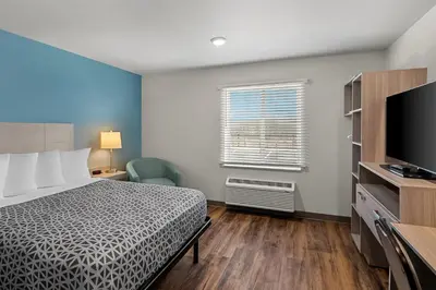 a hotel room with a bed and a tv at WoodSpring Suites Newington - Hartford South in Newington