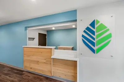 a room with blue walls and a large mirror at WoodSpring Suites Newington - Hartford South in Newington