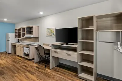 an office with a desk with a computer and a tv at WoodSpring Suites Newington - Hartford South in Newington