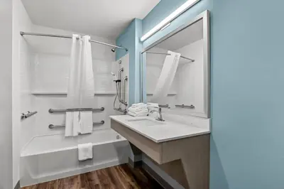 a bathroom with a sink and a mirror at WoodSpring Suites Newington - Hartford South in Newington