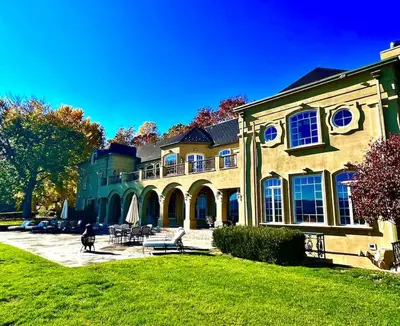 a large house with a person walking in front of it at Chateau Montreau on Hudson in Newburgh
