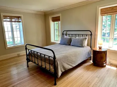 a bedroom with a black bed with a table and windows at Chateau Montreau on Hudson in Newburgh