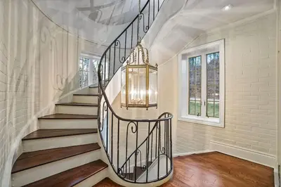 a staircase in a home with a chandelier at Chateau Montreau on Hudson in Newburgh