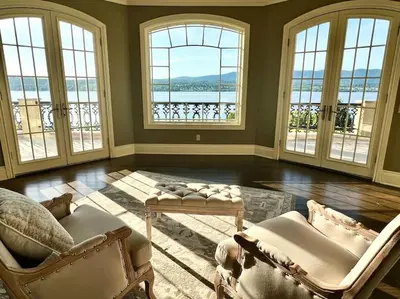 a living room with two chairs and windows with a view at Chateau Montreau on Hudson in Newburgh