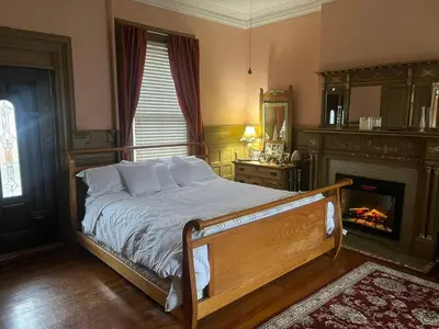a bedroom with a bed with a fireplace and a fire place at 2 Br Victorian Apt 2800 sq ft 2 floors with Full Kitchen 2 baths and Laundry in Poughkeepsie