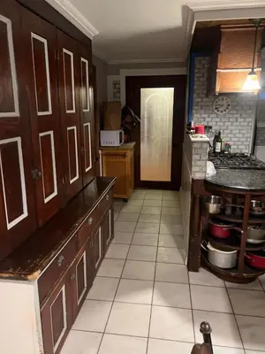 a kitchen with wooden cabinets and a tile floor at 2 Br Victorian Apt 2800 sq ft 2 floors with Full Kitchen 2 baths and Laundry in Poughkeepsie