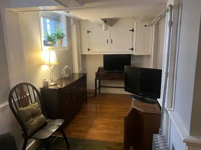 a living room with a television and a desk with a chair at 2 Br Victorian Apt 2800 sq ft 2 floors with Full Kitchen 2 baths and Laundry in Poughkeepsie