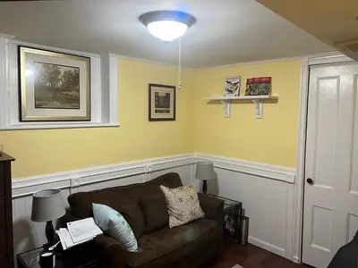 a living room with a couch and yellow walls at 2 Br Victorian Apt 2800 sq ft 2 floors with Full Kitchen 2 baths and Laundry in Poughkeepsie