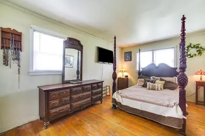 a bedroom with a bed and a dresser and a mirror at Cozy Ballston Spa Home with Fenced Yard! in Malta