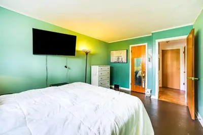 a bedroom with a bed and a flat screen tv on the wall at Cozy Ballston Spa Home with Fenced Yard! in Malta
