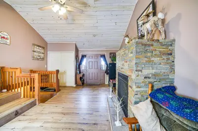 a living room with a brick fireplace and a ceiling at Cozy Ballston Spa Home with Fenced Yard! in Malta