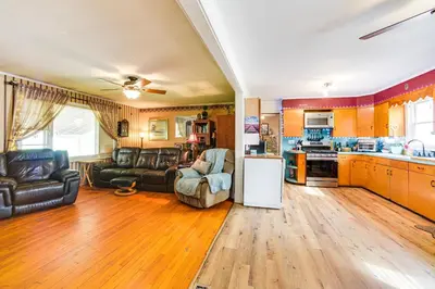 a kitchen and living room with a couch and a refrigerator at Cozy Ballston Spa Home with Fenced Yard! in Malta