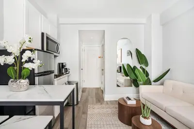 a white living room with a couch and a table at 73-318 New Studio UWS Doorman Gym in New York