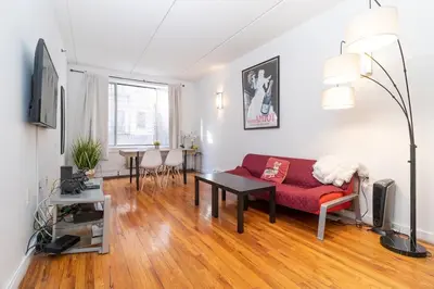 a living room with a red couch and a table at Central Park North - Quiet Place in New York
