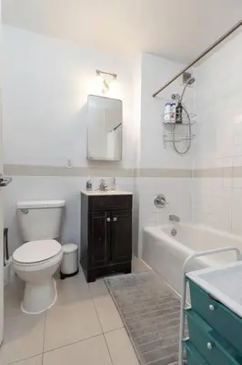 a bathroom with a toilet and a tub and a sink at Central Park North - Quiet Place in New York