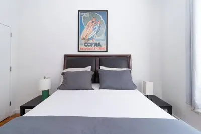 a bedroom with a large bed with a poster at Central Park North - Quiet Place in New York