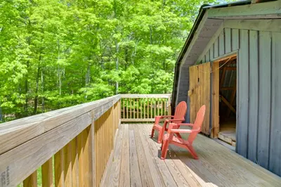 two red chairs sitting on the deck of a cabin at Catskills Family Retreat Fishing and Hiking On-Site in East Durham