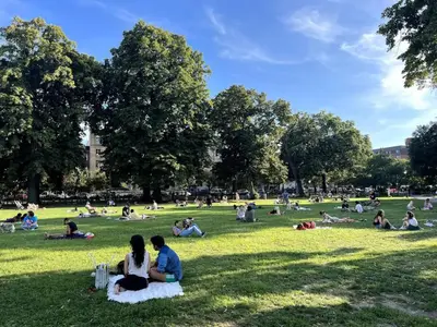 people sitting in the grass in a park at Tuk Ahoy - Sapphire Suite 1B with Shared Spaces in Brooklyn