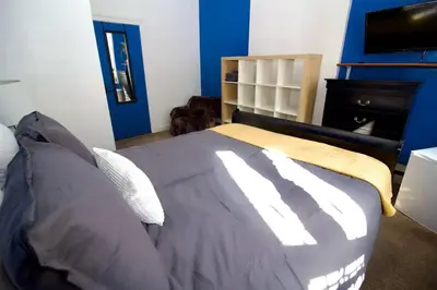 a bedroom with a bed with a blue wall at Tuk Ahoy - Sapphire Suite 1B with Shared Spaces in Brooklyn