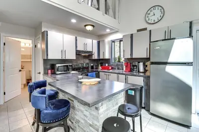 a kitchen with a counter and a refrigerator at Hot Tub and Lake Beach Access Tobyhanna Retreat! in Tobyhanna