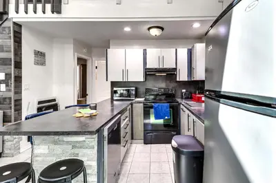 a kitchen with white cabinets and a black counter top at Hot Tub and Lake Beach Access Tobyhanna Retreat! in Tobyhanna